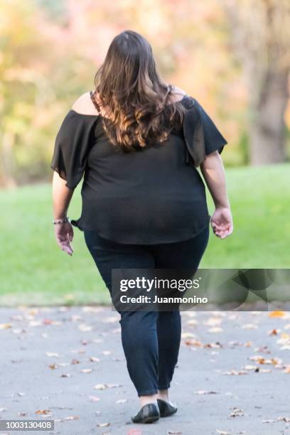 overweight woman walking from behind - adipose cell stock pictures, royalty-free photos & images