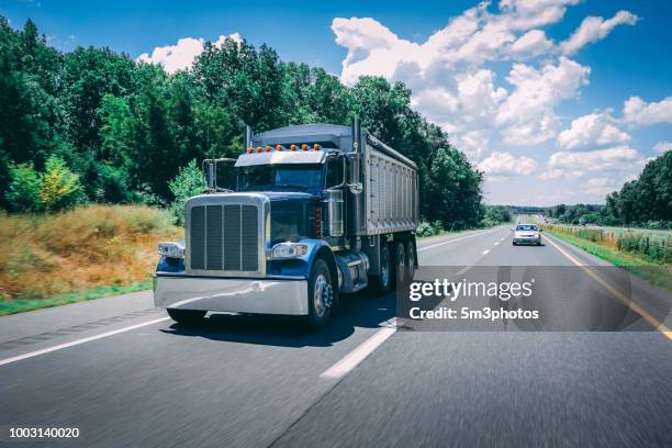 blue dump truck on the highway - camión de descarga fotografías e imágenes de stock