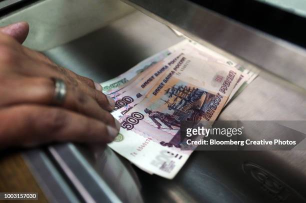 russian 500 and 1000 denomination ruble banknotes sit in a cashier's tray - russian rouble note stock pictures, royalty-free photos & images