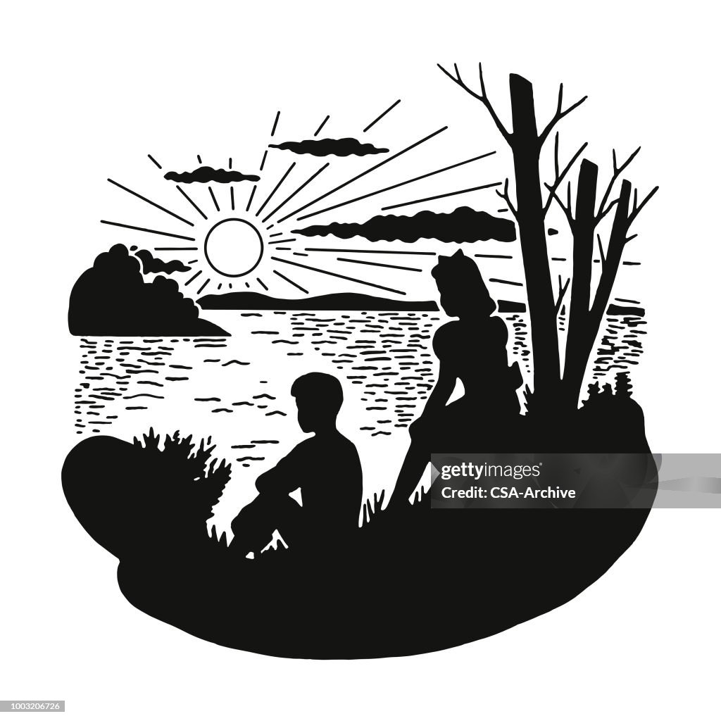 Zwei Kinder sitzen am Seeufer