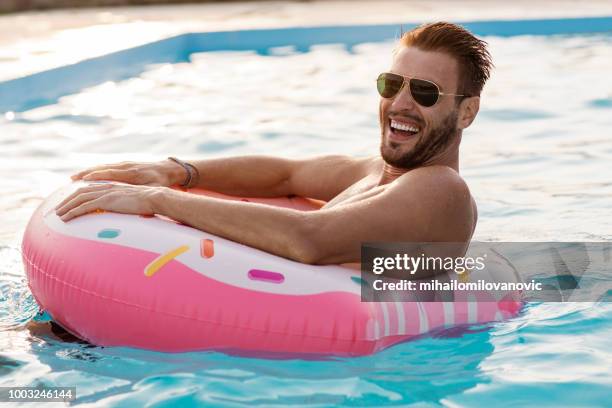 ontspannen in het zwembad - opblaasband stockfoto's en -beelden