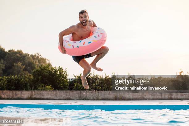 a jump with inflatable ring - swimming pool stock pictures, royalty-free photos & images