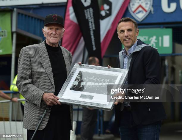 Former Manchester United player Phil Neville presents former Manchester United and Northern Ireland player Harry Gregg with a framed photograph of...