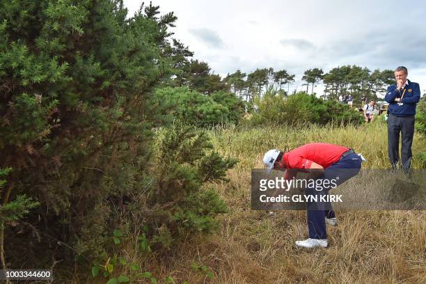 Golfer Zach Johnson examines his ball under some gorse off the 12th fairway during his third round on day 3 of The 147th Open golf Championship at...