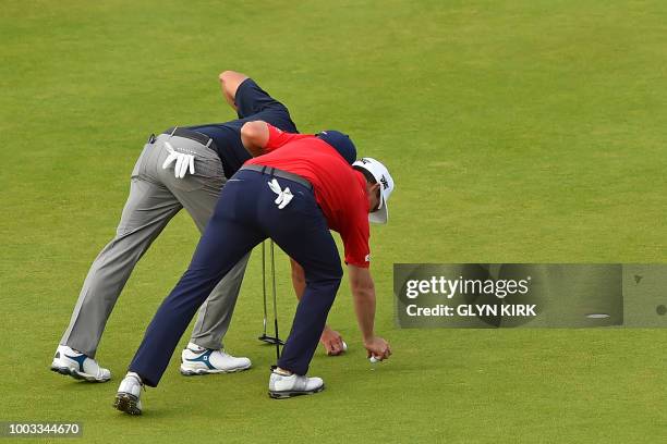 Golfer Kevin Kisner and US golfer Zach Johnson mark their balls on the 17th green during their third rounds on day 3 of The 147th Open golf...
