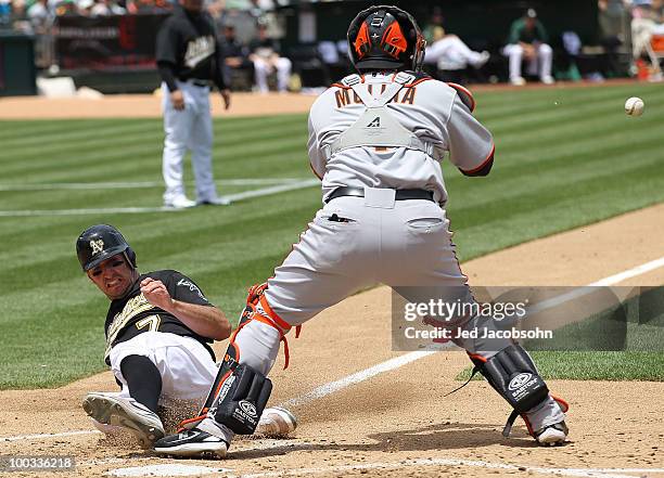 Adam Rosales of the Oakland Athletics slides home safe as Bengie Molina of the San Francisco Giants waits for the throw on a sacrafice fly hit by...