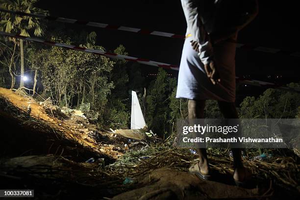 An onlooker observes the airline crash site after recovery operations have concluded for the day May 22, 2010 in Mangalore, India. An Air India...