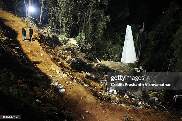 Members of a television crew walk past debris at the airline crash site May 22, 2010 in Mangalore, India. An Air India Express Boeing 737-800 series...