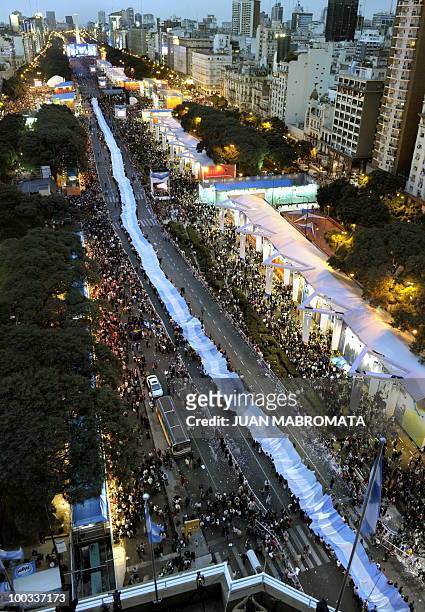 People hold a huge Argentine flag along 9 de Julio avenue, in Buenos Aires on May 22, 2010 as part of the celebrations for the Bicentenary of the May...
