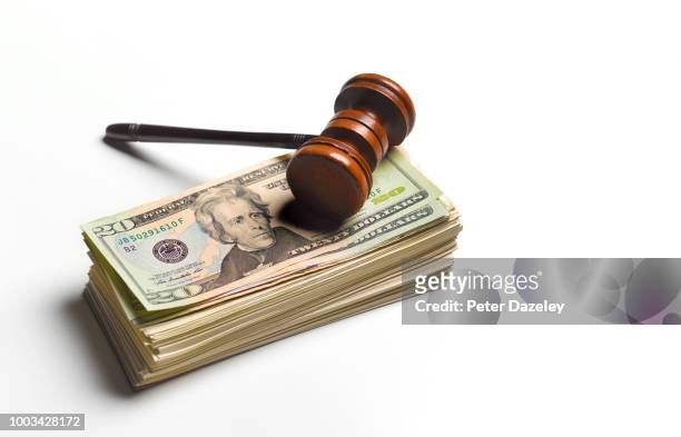 gavel sitting on pile of dollars - money penalty stock pictures, royalty-free photos & images