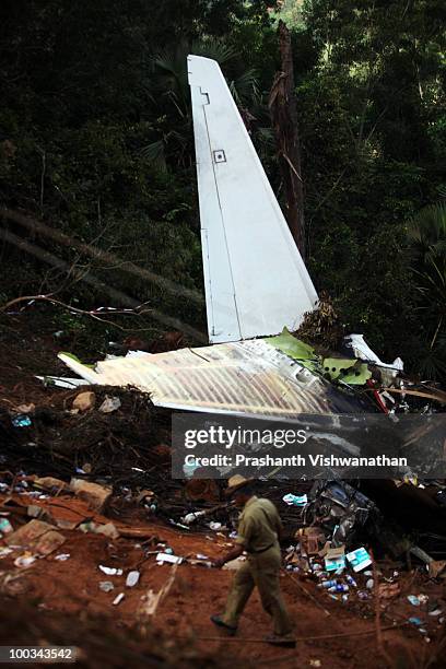Local policeman walks past the plane crash site on May 23, 2010 in Mangalore. An Air India Express Boeing 737-800 series aircraft arriving from...