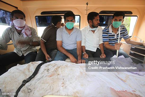 Relatives travel with the body of a family member to another mortuary on May 23, 2010 in Mangalore. An Air India Express Boeing 737-800 series...