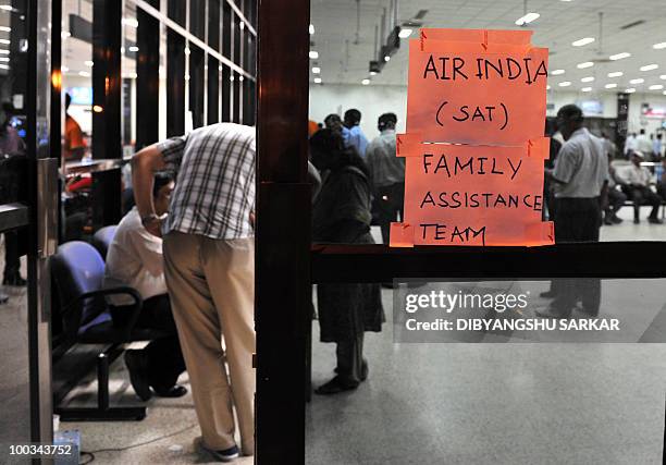 Employees of Air India work at a booth to assist family members of passengers on an Air India Boeing 737-800 aircraft which crashed upon landing in...