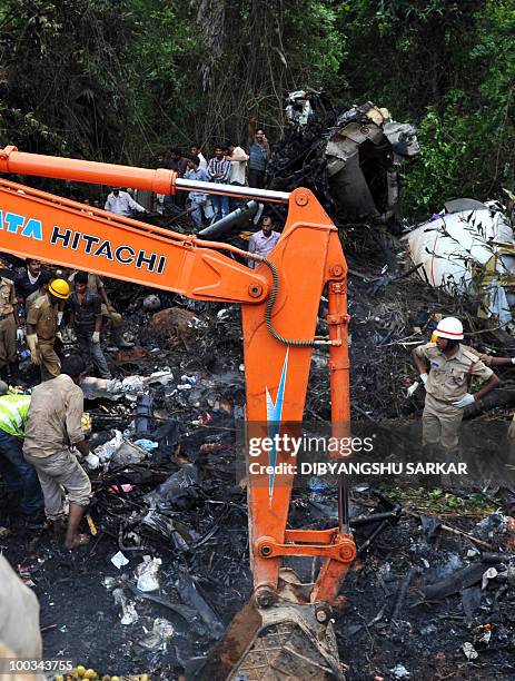 Rescue personnel and volunteers work at the crash site of an Air India Boeing 737-800 aircraft which crashed upon landing in Mangalore on May 22,...