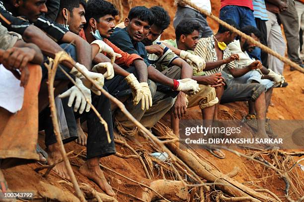 Rescue personnel and volunteers rest at the crash site of an Air India Boeing 737-800 aircraft which crashed upon landing in Mangalore on May 22,...