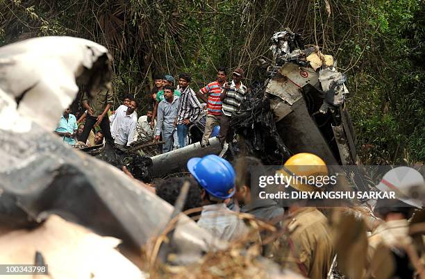 Rescue personnel and volunteers work at the crash site of an Air India Boeing 737-800 aircraft which crashed upon landing in Mangalore on May 22,...