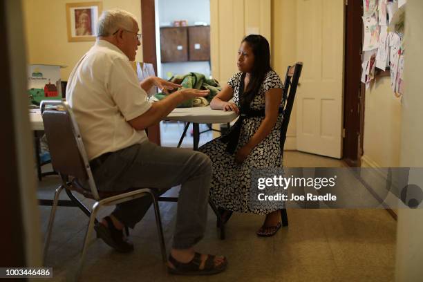 Woman, identified only as Maria, sits with Ruben Garcia, director of the Annunciation House, informs her that she will be cared for by them in an...