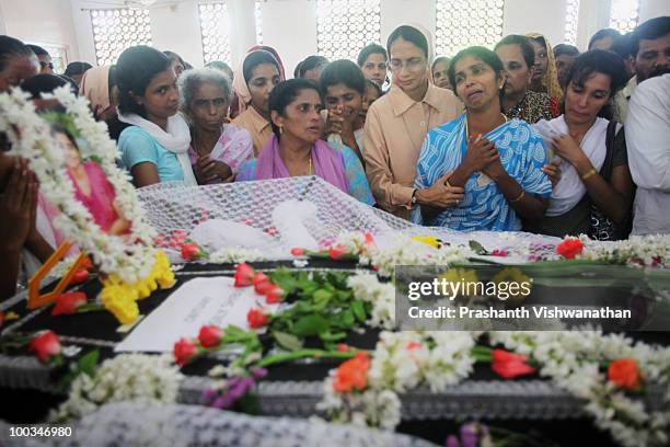 Relatives of Air India Express crash victim H. Goldine mourn beside the coffin during a funeral service at the St. Alphonsa Catholic Church, on May...