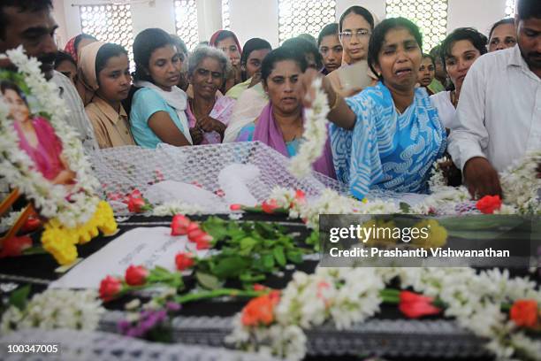 Relatives of Air India Express crash victim H. Goldine mourn beside the coffin during a funeral service at the St. Alphonsa Catholic Church, on May...