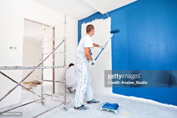 hausmaler anfang zu eine großen blaue wand malen - malermeister stock-fotos und bilder