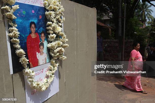 Photograph of H.Rosaline and her two daughters H.Goldine and H.Gloria, victims of an Air India Express plane crash, is displayed at the gate during...