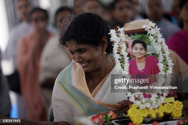 Realtive of Air India Express crash victim H. Rosaline and her two daughters, mourns over their coffins, at the St. Alphonsa Catholic Church, on May...