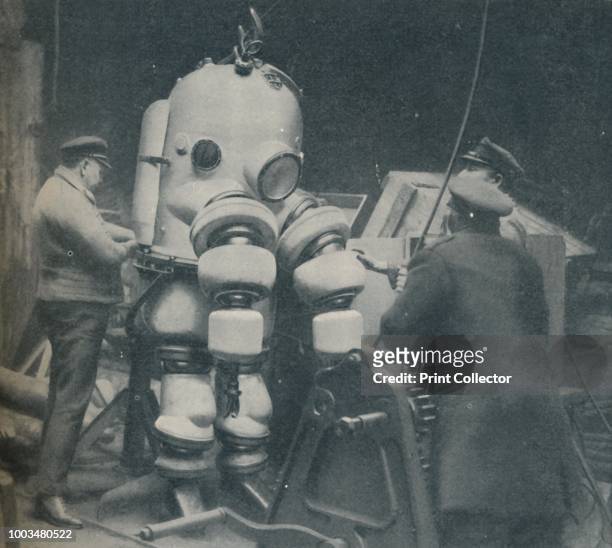 Going Down at Short Notice: A British Diver Preparing To Seek a Submarine at Sea Bottom', circa 1935. From Our Wonderful World, Volume I, edited by...