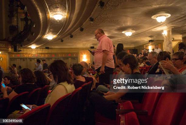 Theater goers wait for the the opening act of "Angels In America" to begin July 13, 2018 at the Neil Simon Theater in New York City. The revived Tony...