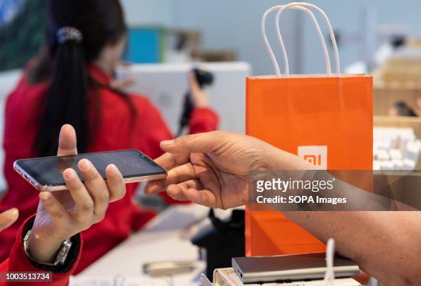 Xiaomi employee seen assisting a customer inside at Hong Kong flagship store.