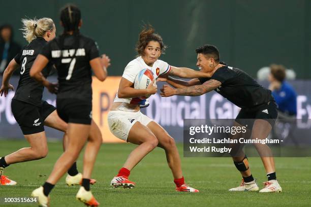 Coralie Bertrand of France is tackled by Gayle Broughton of New Zealand during the Championship match on day two of the Rugby World Cup Sevens at...