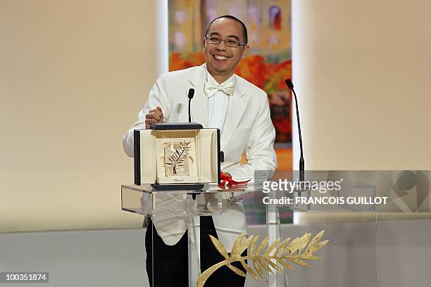 Thai director Apichatpong Weerasethakul poses after receiving the Palm d�Or award for his film "Lung Boonmee Raluek Chat" during the closing ceremony...