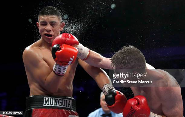 Junior middleweight champion Jaime Munguia of Mexico takes a punch from Liam Smith of England during their title fight on July 21, 2018 in Las Vegas,...