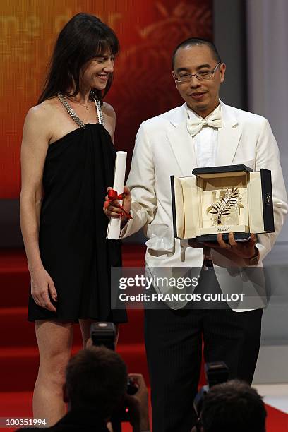 Thai director Apichatpong Weerasethakul poses next to French actress Charlotte Gainsbourg after receiving the Palm d�Or award for his film "Lung...