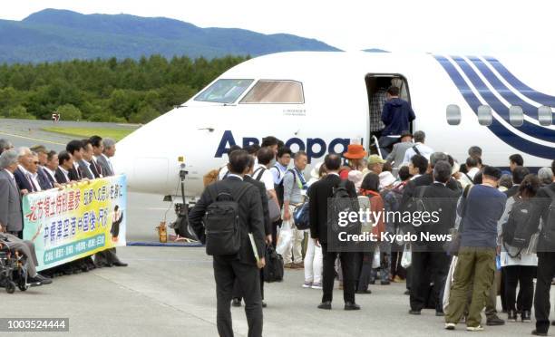 Former residents board a chartered airplane at Nakashibetsu airport in Hokkaido on July 22 to visit their ancestors' graves on Russian-held Kunashiri...