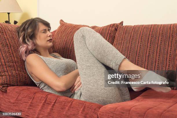 menstrual cramps - woman holding tummy stock-fotos und bilder