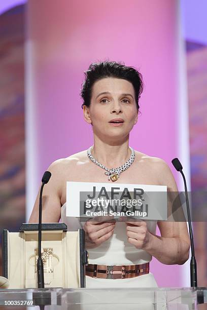 Actress Juliette Binoche holds a sign reading the name of Iranian director Jafar Panahi after winning the Best Actress award for her role in...