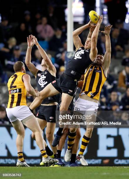 Liam Jones of the Blues marks the ball ahead of Jonathon Ceglar of the Hawks during the 2018 AFL round 18 match between the Carlton Blues and the...