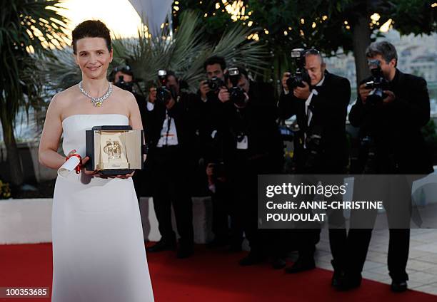 French actress Juliette Binoche poses after winning the Best Actress award for her role "Copie Conforme" during the closing ceremony at the 63rd...