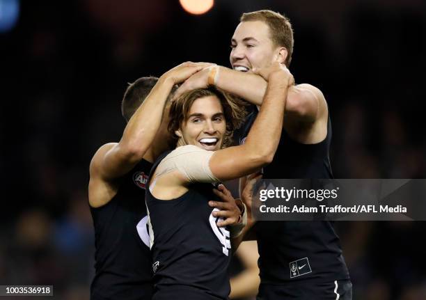 Cameron Polson of the Blues celebrates his first AFL goal with Jarrod Pickett and Harry McKay of the Blues during the 2018 AFL round 18 match between...