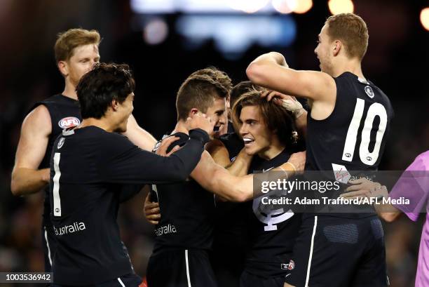 Cameron Polson of the Blues celebrates his first AFL goal with L-R Jack Silvagni, Marc Murphy, Jarrod Pickett, and Harry McKay of the Blues during...