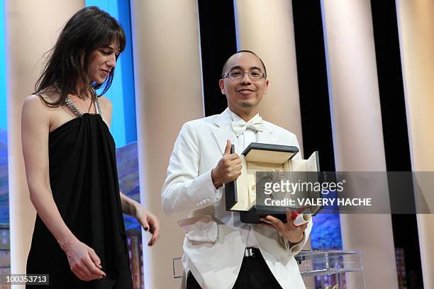 Thai director Apichatpong Weerasethakul poses next to French actress Charlotte Gainsbourg after receiving the Palm d�Or award for his film "Lung...