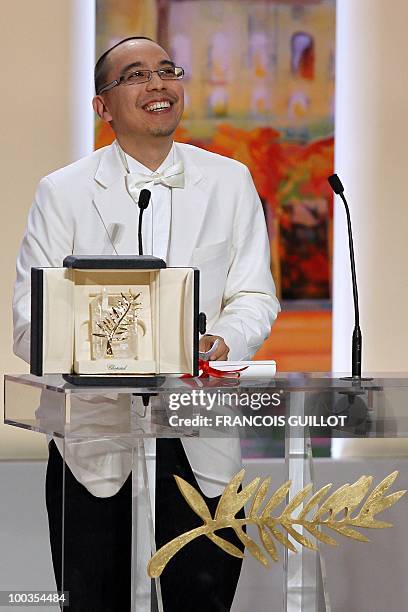 Thai director Apichatpong Weerasethakul poses after receiving the Palm d�Or award for his film "Lung Boonmee Raluek Chat" during the closing ceremony...