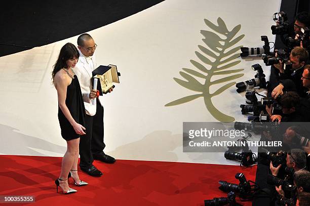 Thai director Apichatpong Weerasethakul poses next to French actress Charlotte Gainsbourg after receiving the Palm d�Or award for his film "Lung...