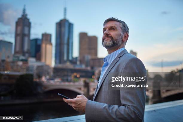 success businessman at dusk in melbourne centre city - australia city night stock pictures, royalty-free photos & images