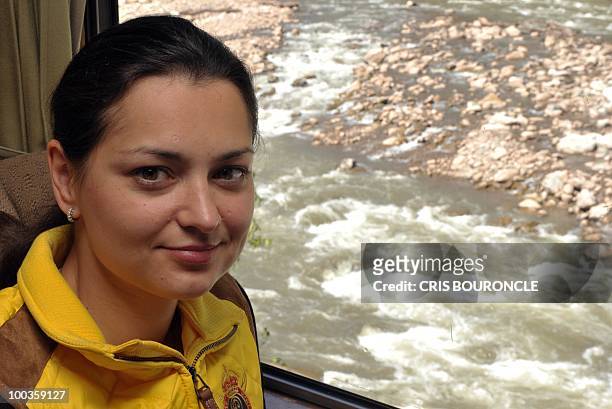 World chess champion Russian Alexandra Kosteniuk sits in a train as it moves by the torrential river Vilcanota on the way to the Inca citadel of...