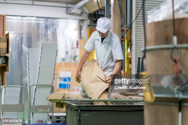 trabajador en una fábrica de procesamiento de alimentos - cereal plant fotografías e imágenes de stock