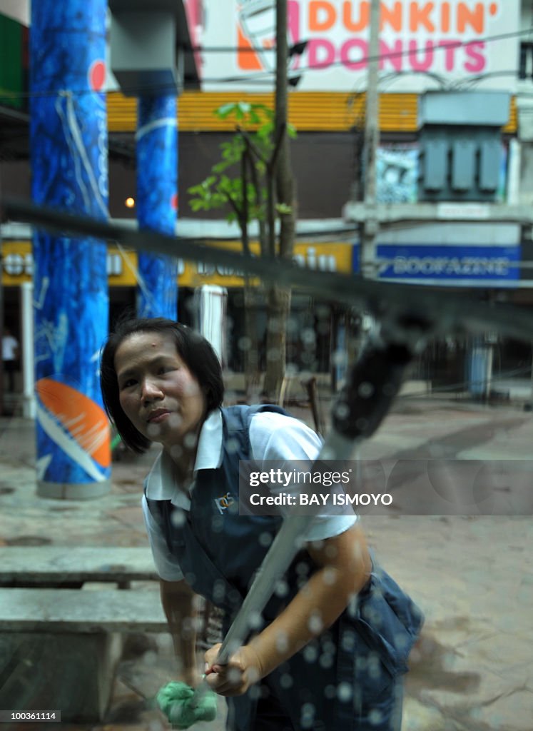 A worker cleans the glass door as they o