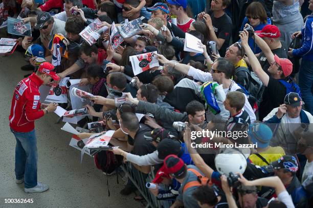 Casey Stoner of Australia and Ducati Marlboro Team signs autographs for fans before the first free practice of the MotoGP French Grand Prix in Le...