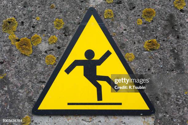 sign beware slippy on concrete wall - slippery stock-fotos und bilder