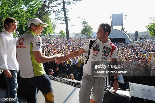 Aleix Espargaro of Spain and Pramac Green Energy Team greets Randy De Puniet of France and LCR Honda MotoGP in front of the fans during the event...